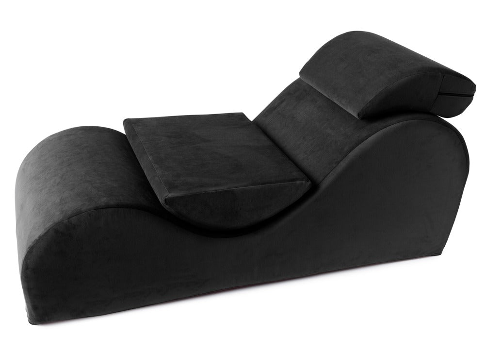Liberator Esse Lounger – schwarze ergonomische Sex-Lounge mit geschwungener Liegefläche, erhöhten Polsterbereichen und zwei zusätzlichen schwarzen Stützkissen in schräger Gesamtansicht auf weißem Hintergrund – erhältlich bei Evoria Care