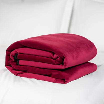 Liberator Fascinator Throw – bordeauxrote Liebesdecke mit weicher Oberfläche und schwarzer Randeinfassung, kompakt zusammengefaltet auf weißem Hintergrund – erhältlich bei Evoria Care