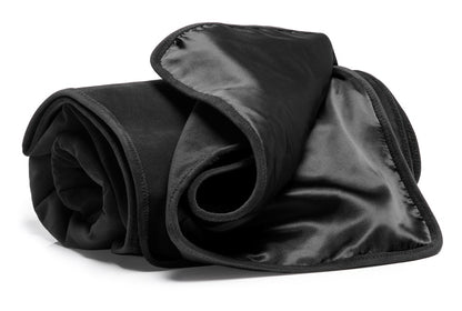 Liberator Fascinator Throw – schwarze Premium-Liebesdecke mit glänzender und matter Textilseite, weicher Oberfläche und umgeschlagener Stoffkante, locker zusammengerollt in schräger Produktansicht auf weißem Hintergrund – erhältlich bei Evoria Care