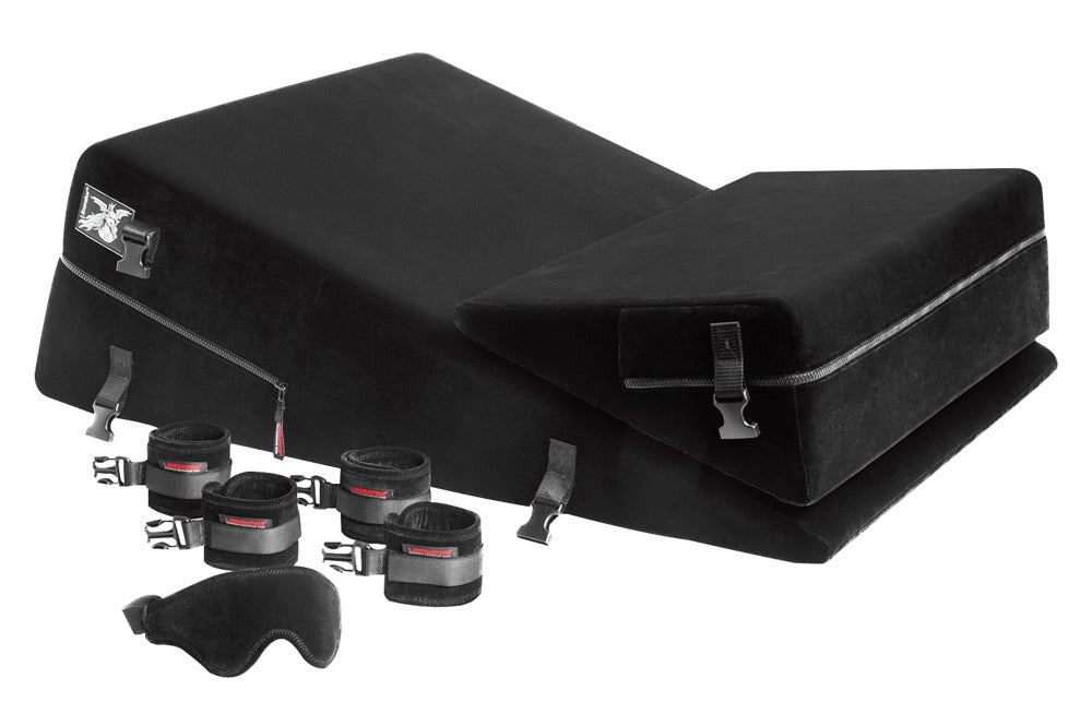 Liberator Wedge/Ramp Black Label – schwarzes Premium-Positionierungsset aus zwei ergonomischen Keilkissen mit seitlichen Befestigungselementen, Metallringen und separat dargestelltem Bondage-Zubehör in schräger Produktansicht auf weißem Hintergrund – erhältlich bei Evoria Care