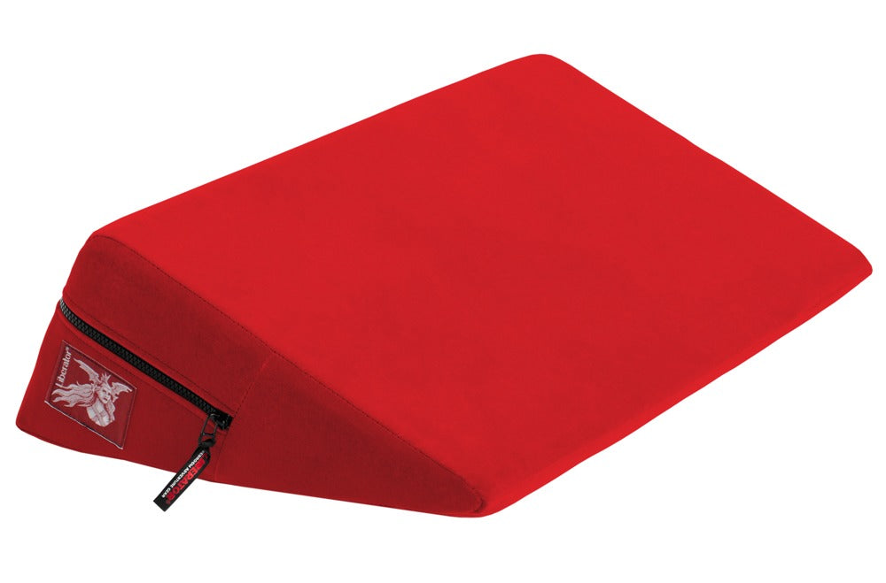 Liberator Wedge – rotes ergonomisches Positionierungskissen mit keilförmiger Polsterung, glatter Liegefläche, flach zulaufender Vorderkante und seitlichem Liberator Markenetikett in schräger Produktansicht auf weißem Hintergrund – erhältlich bei Evoria Care