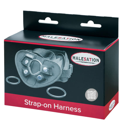 MALESATION Strap-on Harness – schwarz-rote Originalverpackung des verstellbaren Dildogurts mit Abbildung der drei Wechselringe, MALESATION Markenlogo und Produktbezeichnung Strap-on Harness – erhältlich bei Evoria Care