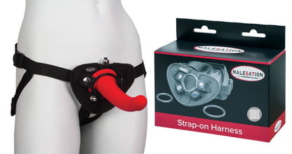 MALESATION Strap-on Harness – schwarzer verstellbarer Dildogurt mit Hüft- und Schrittgurten, rotem Befestigungsring und drei austauschbaren Ringen, an einer weißen Schaufensterpuppe neben der schwarz-roten Originalverpackung dargestellt – erhältlich bei Evoria Care
