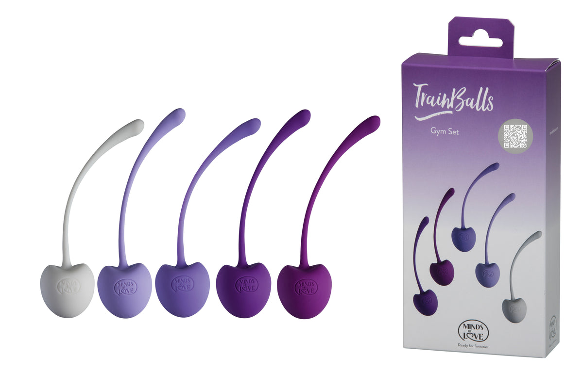 MINDS of LOVE TrainBalls Gym Set mit fünf Beckenbodenkugeln in Grau und abgestuften Lilatönen, jeweils mit gebogener Rückholschlaufe, dargestellt neben der violett-weißen Originalverpackung – erhältlich bei Evoria Care
