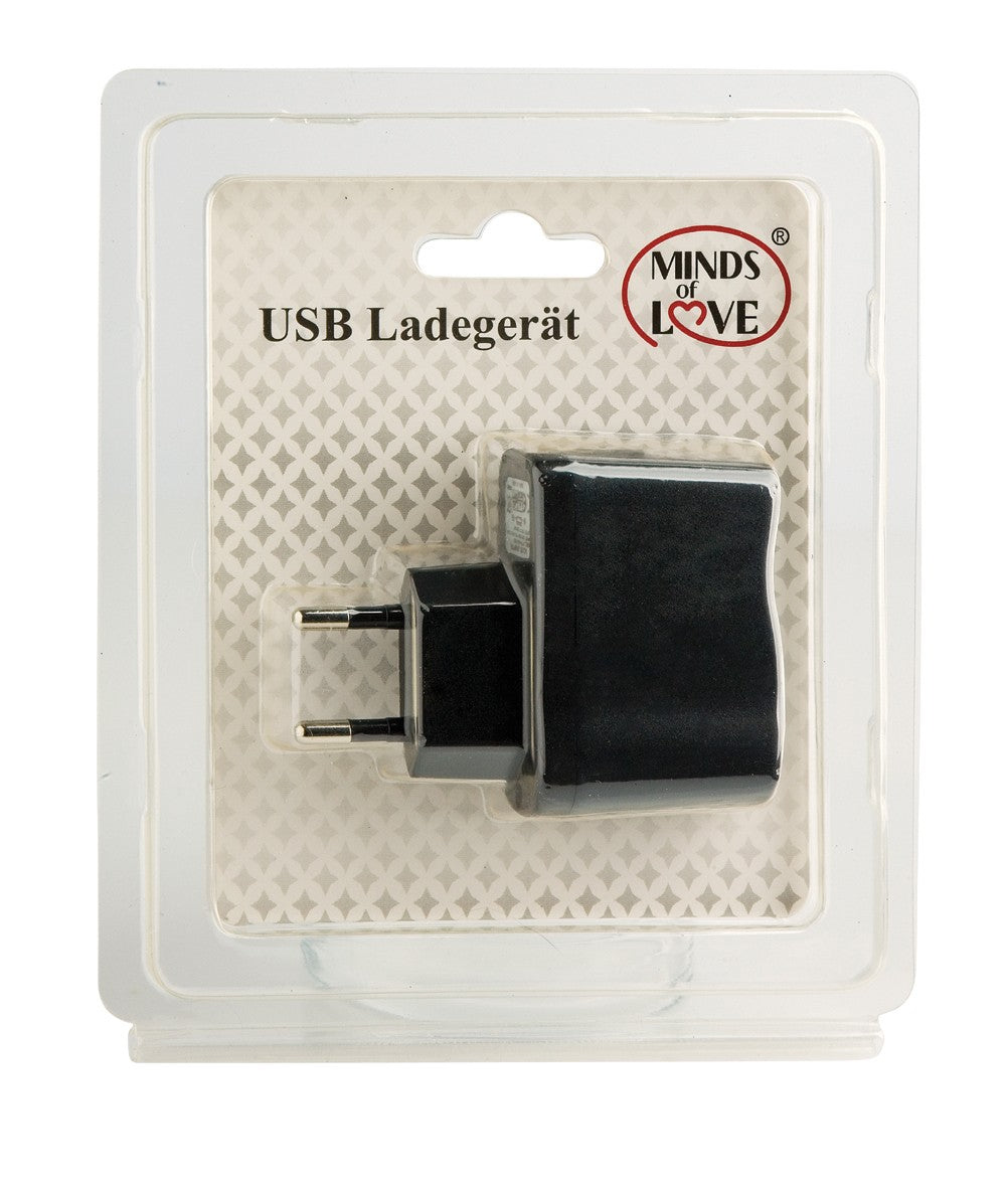 MINDS of LOVE USB-Ladegerät in Schwarz mit zweipoligem EU-Netzstecker und USB-Anschluss, dargestellt in transparenter Originalverpackung mit weißem Produktetikett und Markenlogo – erhältlich bei Evoria Care