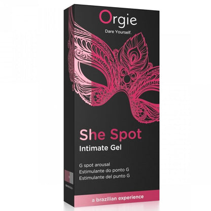 ORGIE She Spot – schwarz-pinkfarbene Originalverpackung des G-Punkt-Stimulationsgels mit großem She Spot Schriftzug, dekorativem pinkfarbenem Blumenmotiv und ORGIE Markenlogo in aufrechter Vorderansicht auf weißem Hintergrund – erhältlich bei Evoria Care