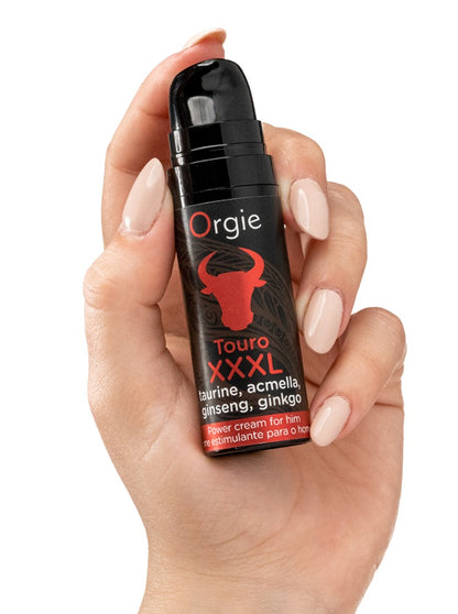 Orgie Touro XXXL Power Cream für Männer in schwarzer Flasche mit rotem Stiermotiv, aufrecht in einer Hand gehalten zur Veranschaulichung von Größe und Handhabung – erhältlich bei Evoria Care