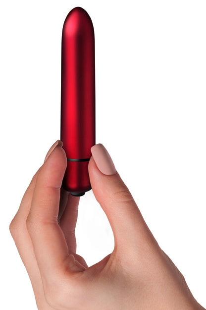Rocks Off Scarlet Velvet Bullet-Vibrator in Rot und Schwarz – Produkt in einer Hand zur Darstellung der kompakten Größe und schlanken Form – erhältlich bei Evoria Care