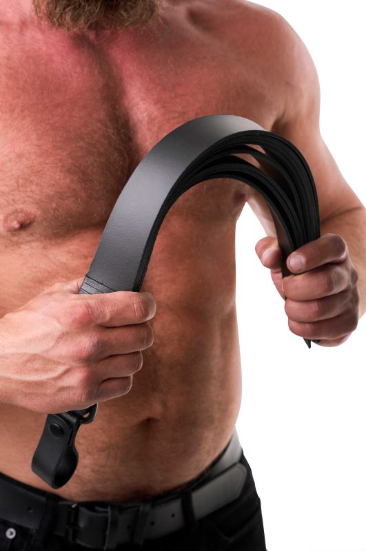 SAXOS Leder Slapper – Anwendungsansicht des schwarzen mehrlagigen Leder-Slappers am männlichen Oberkörper mit sichtbarer breiter Schlagfläche – erhältlich bei Evoria Care