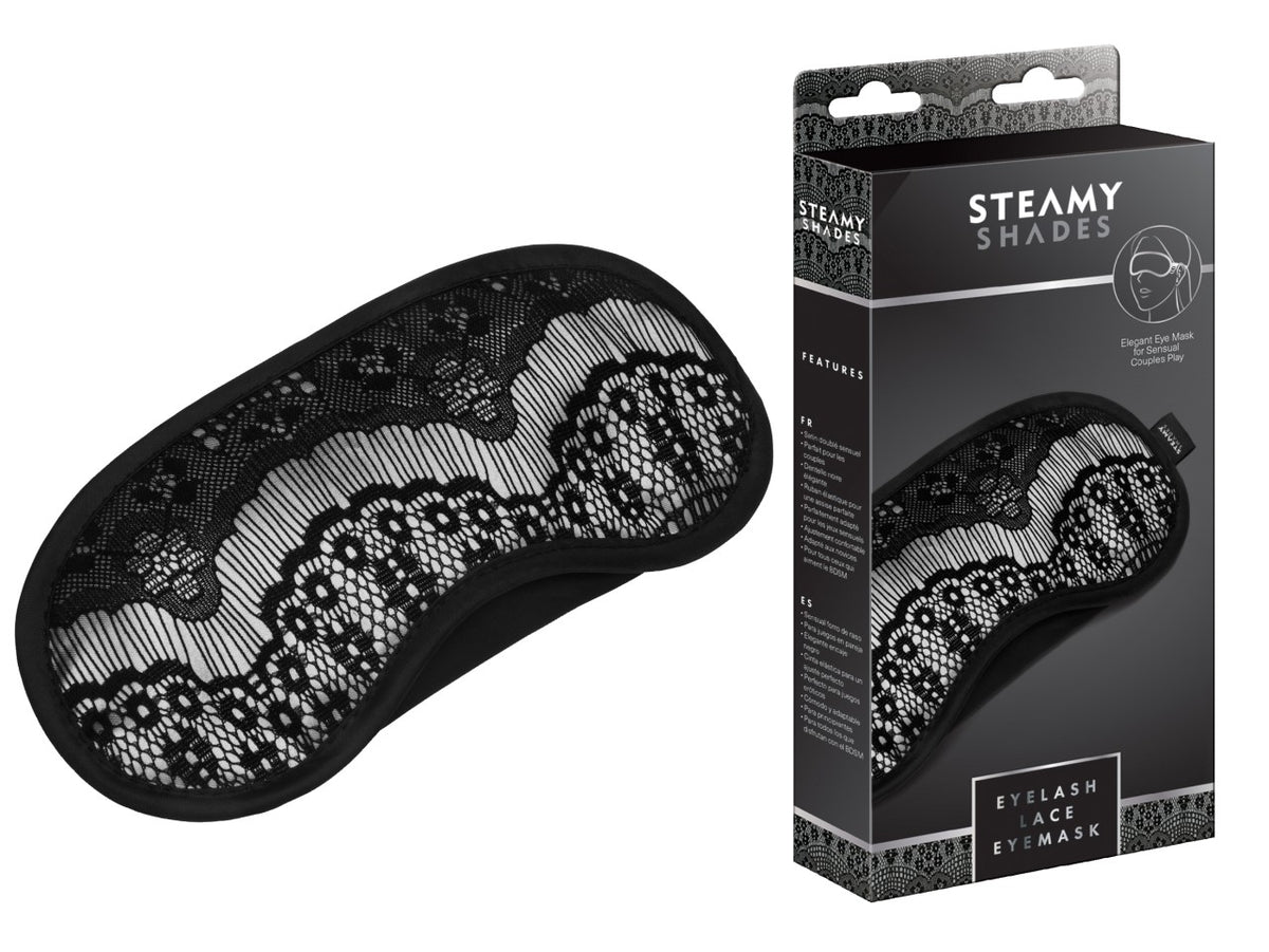 STEAMY SHADES Eyelash Lace Eyemask schwarze Satin-Augenmaske mit floraler Spitzenverzierung, geschwungener Form und schmalem Befestigungsband, dargestellt neben der schwarzen Originalverpackung – erhältlich bei Evoria Care