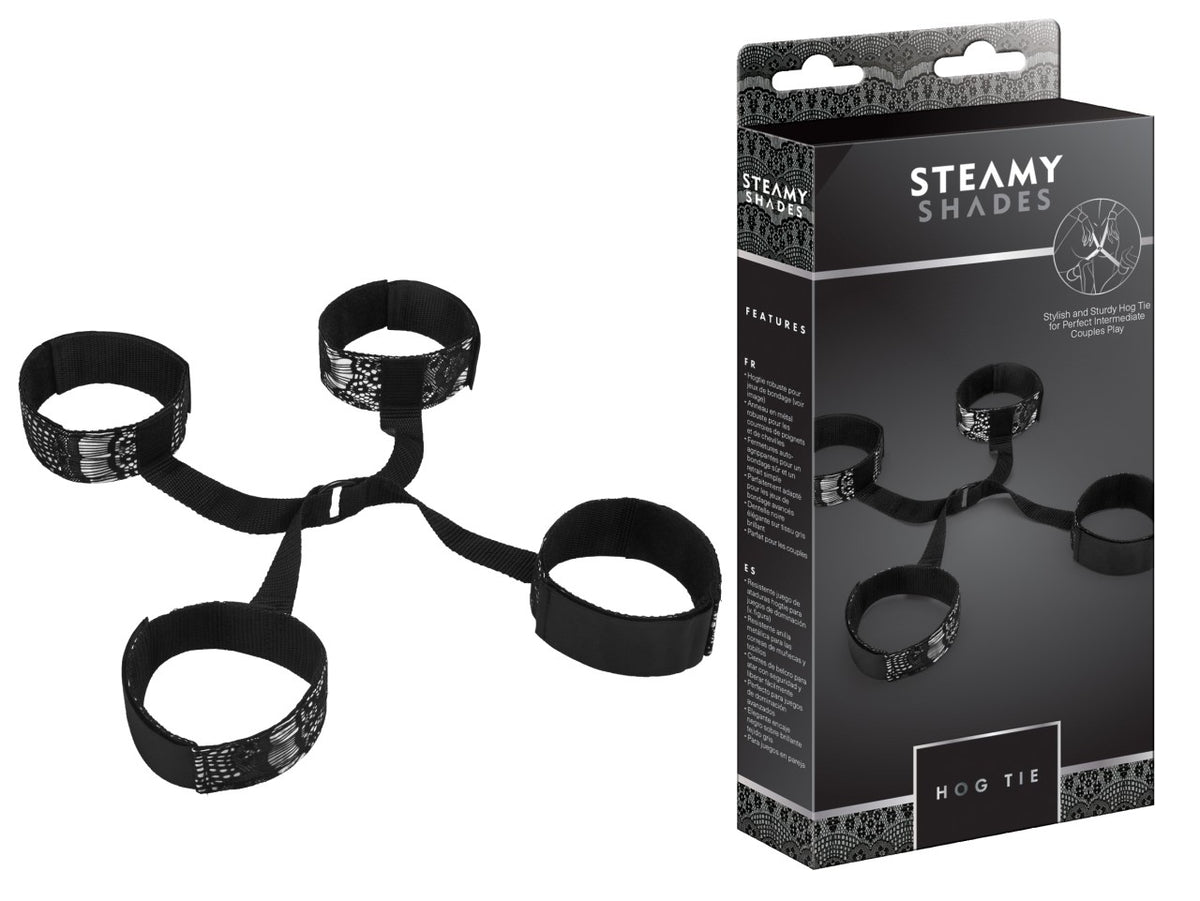 STEAMY SHADES Hog Tie Hand- und Fußfesseln in Schwarz mit vier verstellbaren Fesselmanschetten, zentralem Verbindungsring und schwarzen Riemen, dargestellt neben der schwarzen Originalverpackung – erhältlich bei Evoria Care