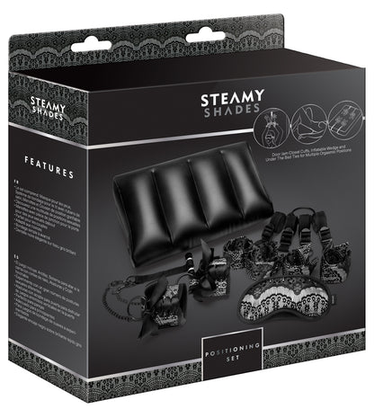 STEAMY SHADES Positioning Set Fesselset mit schwarzem Positionskeil, Augenmaske und Fesselzubehör, dargestellt auf der schwarzen Originalverpackung mit STEAMY SHADES Markenlogo in diagonaler Ansicht – erhältlich bei Evoria Care
