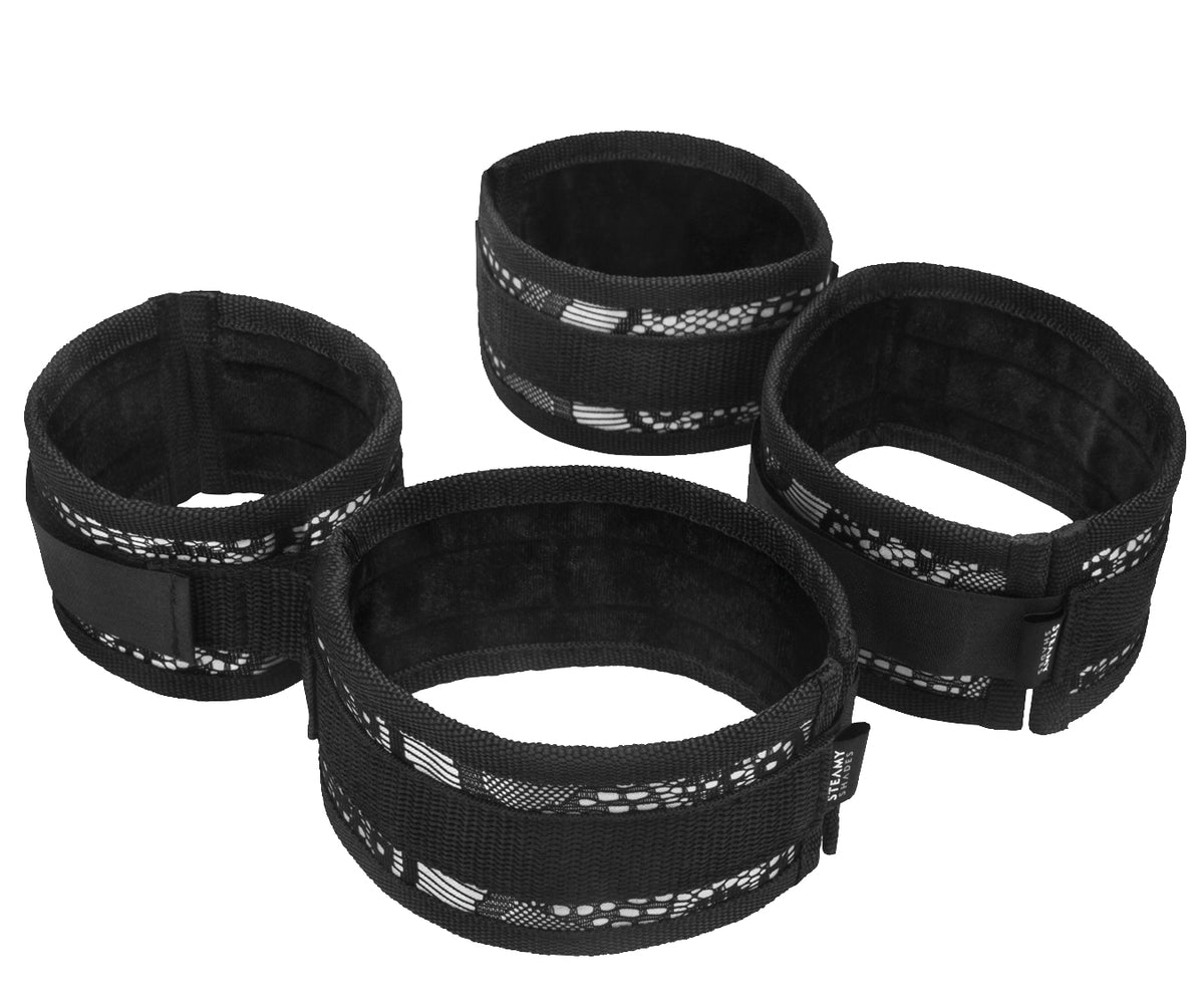 STEAMY SHADES Wrist to Ankle Cuffs Hand- und Fußfesseln in Schwarz mit vier gepolsterten Manschetten, verstellbaren Verschlüssen und Verbindungselementen in freigestellter Gesamtansicht auf weißem Hintergrund – erhältlich bei Evoria Care