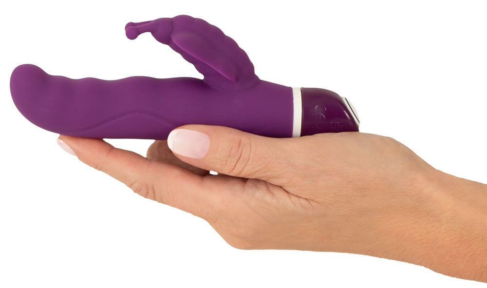 Sweet Smile G-Butterfly in Dunkelviolett – Produkt in einer Hand zur Darstellung von Größe, Form und seitlichem Stimulationsarm – erhältlich bei Evoria Care