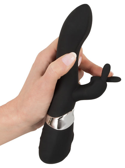 Sweet Smile Rechargeable Rabbit in Schwarz – Darstellung der flexiblen Form des Hauptschafts und seitlichen Stimulationsarms in einer Hand – erhältlich bei Evoria Care