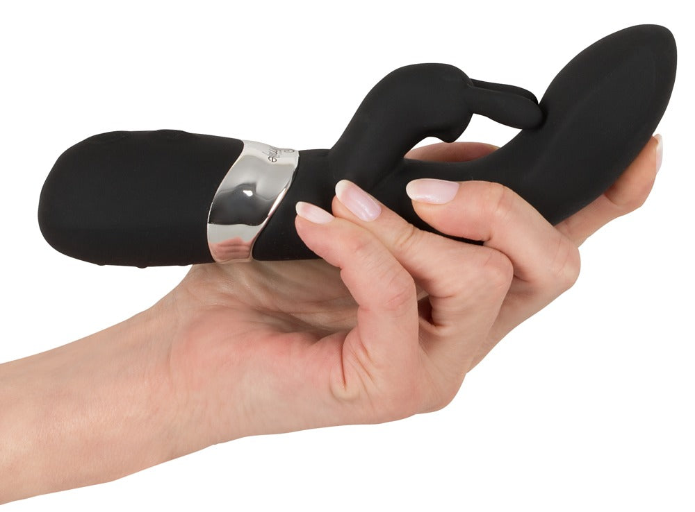 Sweet Smile Rechargeable Rabbit in Schwarz – Rabbitvibrator in einer Hand zur Darstellung von Größe, geschwungener Form und seitlichem Stimulationsarm – erhältlich bei Evoria Care