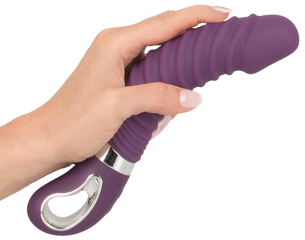 Sweet Smile Warming Soft Wärmevibrator in Dunkelviolett – Darstellung des flexiblen Schafts beim Biegen in einer Hand mit sichtbarem Haltering – erhältlich bei Evoria Care