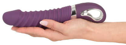 Sweet Smile Warming Soft Wärmevibrator in Dunkelviolett – liegende Produktansicht in einer Hand zur Darstellung von Größe und geschwungener Form – erhältlich bei Evoria Care