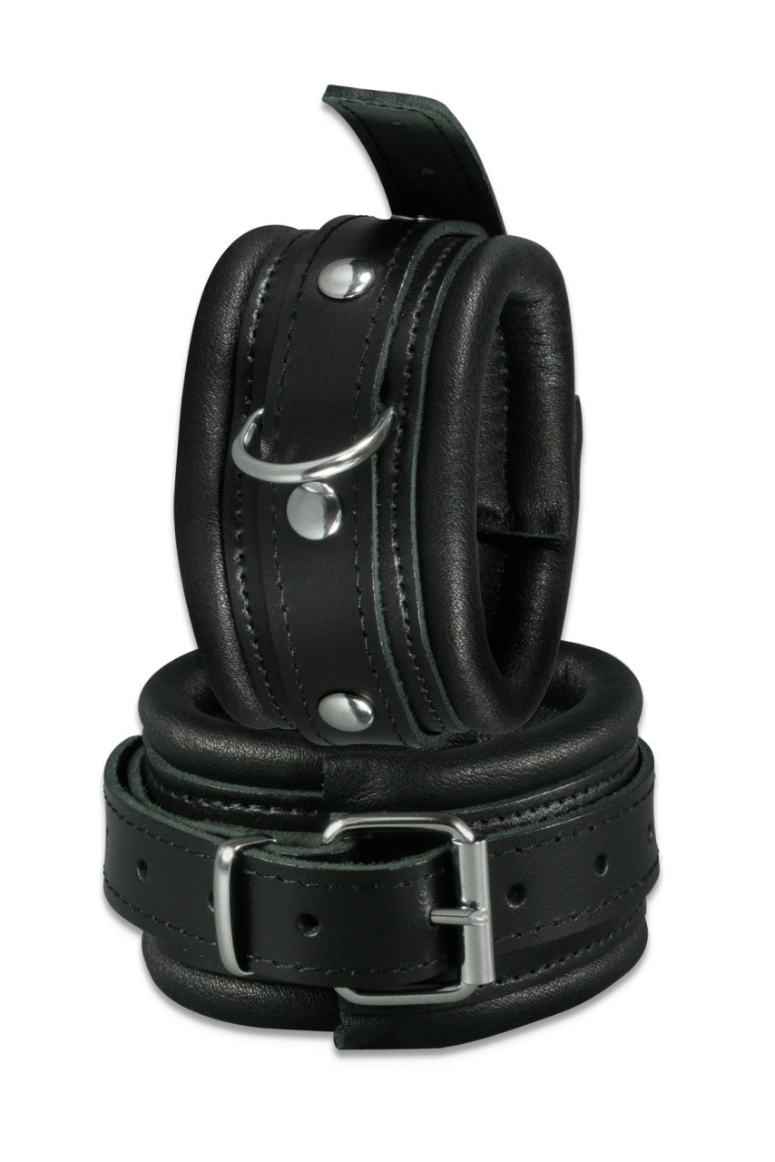 XX-DREAMSTOYS Leder-Fußfessel – schwarze gepolsterte Fußfesseln aus Rindsleder mit breiten Schnallenverschlüssen und Metallösen in einzelner Produktansicht – erhältlich bei Evoria Care