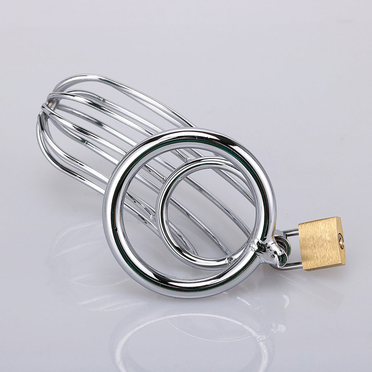 XX-DREAMSTOYS Metal Cock Cage Banana Shape – Frontdetail des Metall-Peniskäfigs mit offener Gitterkonstruktion und Verschlusselement – erhältlich bei Evoria Care