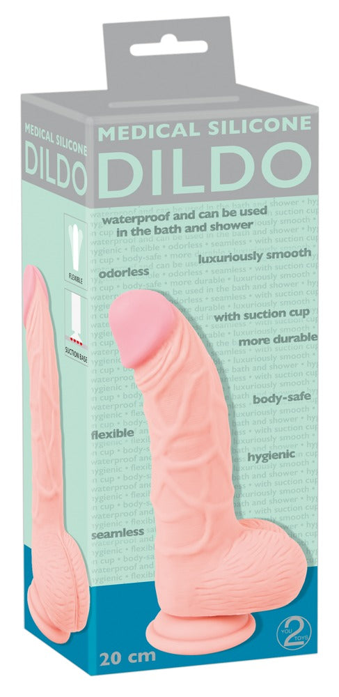 You2Toys Medical Silicone Dildo in Hautfarbe – leicht gebogener Dildo mit Saugfuß zusammen mit der You2Toys Produktverpackung – erhältlich bei Evoria Care