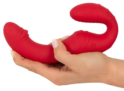 You2Toys RC Strapless Strap-On 3 in Rot – liegende Produktansicht in einer Hand mit deutlich sichtbarer Dual-Form – erhältlich bei Evoria Care