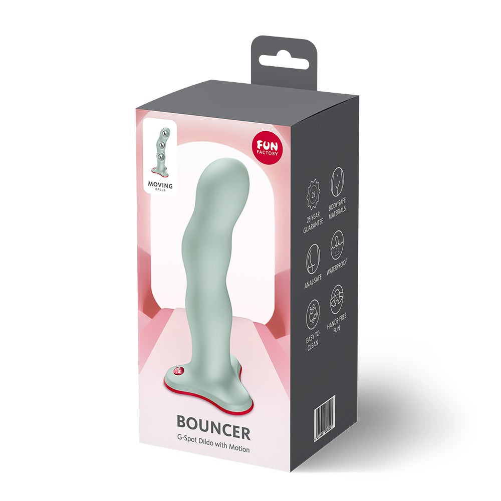 FUN FACTORY BOUNCER Dildo in Mint mit rotem Saugfuß neben der Originalverpackung