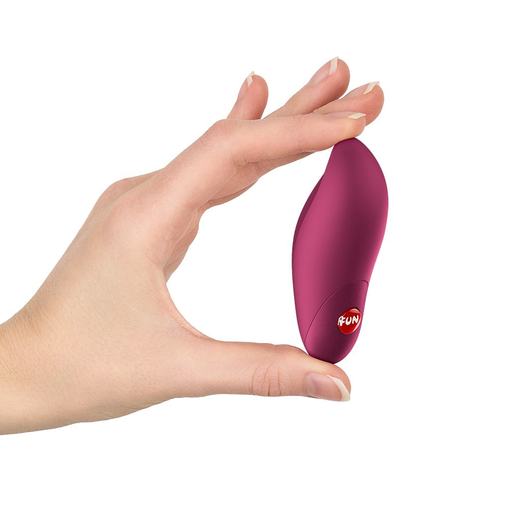 FUN FACTORY CHARME Klitorisvibrator in Pink in einer Hand zur Veranschaulichung der kompakten Produktgröße