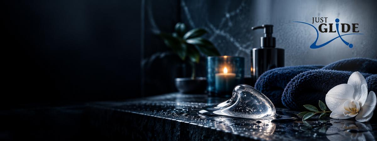 Just Glide Markenseite bei Evoria Care mit transparenter Geltextur auf dunkler nasser Steinfläche in blauer Wellness-Atmosphäre und originalem Just Glide Logo