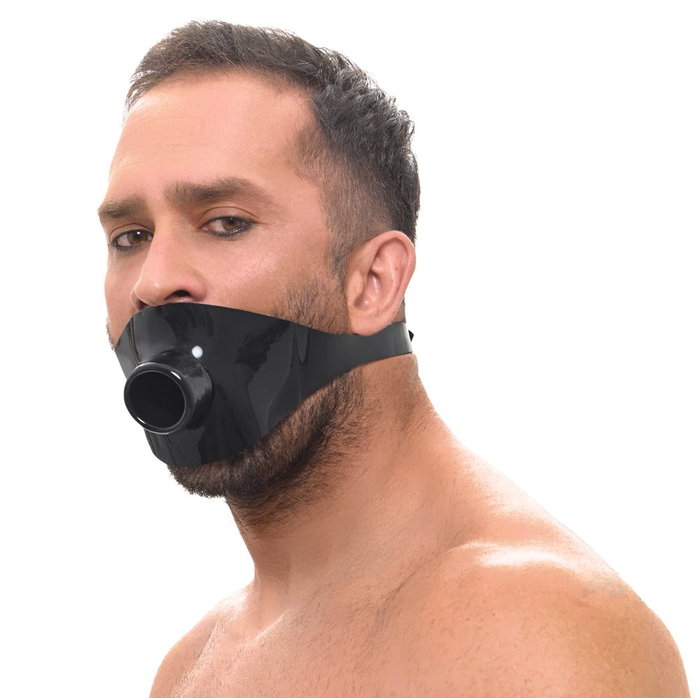 Model trägt die schwarze Late X Latex-Knebelmaske mit offenem Mundrohr in frontaler Ansicht