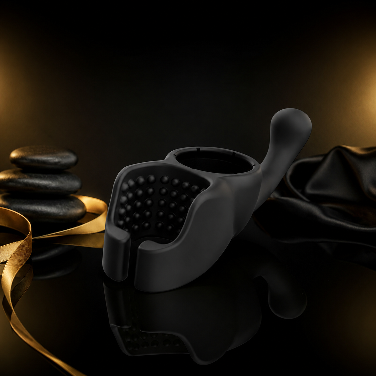 Lovense Domi Male Attachment aus schwarzem Silikon auf luxuriösem schwarzem Studiohintergrund mit goldenen Lichteffekten und spiegelnder Oberfläche.