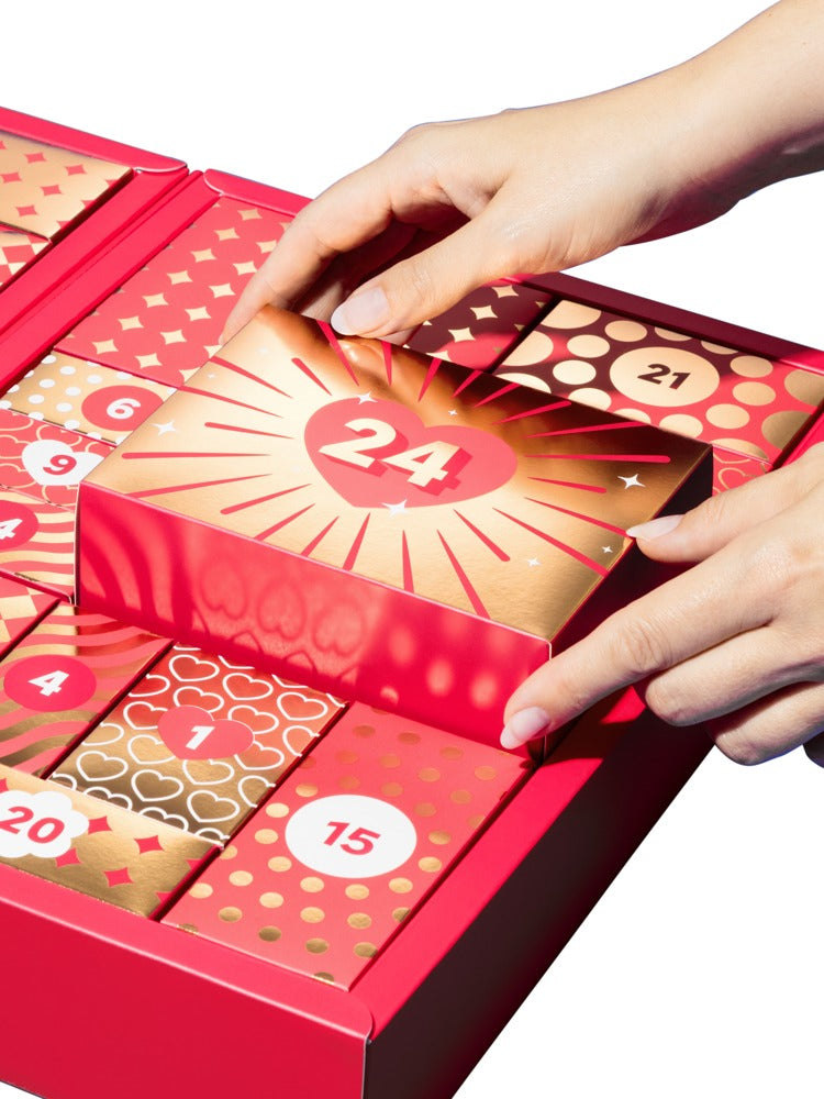 Hände beim Öffnen einer Geschenkbox des Magic Shiver Couples Erotik-Adventskalenders 2026