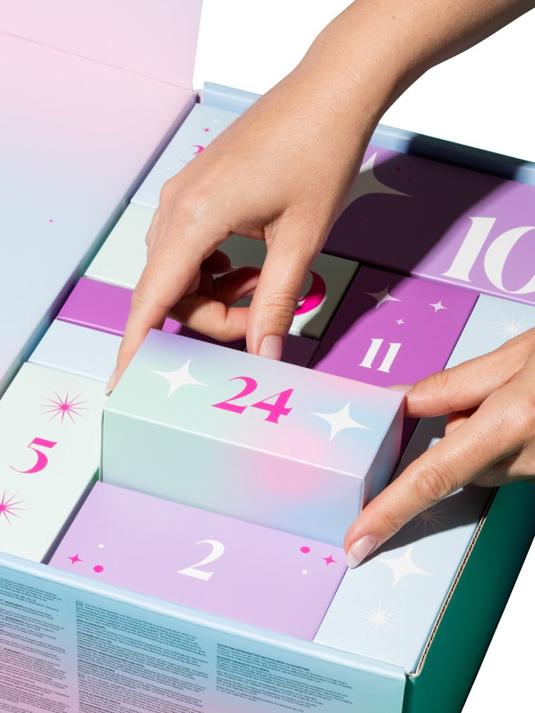Hände beim Öffnen einer Geschenkbox des Magic Shiver Enjoy Erotik-Adventskalenders 2026