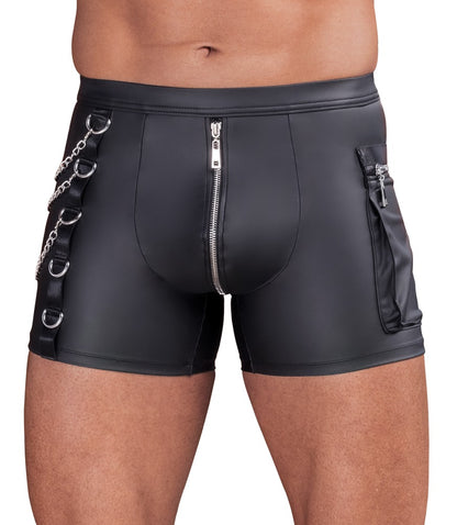 Model in körperbetonten NEK Pants im schwarzen Mattlook mit Front-Zip und seitlichen Karabiner-Ketten