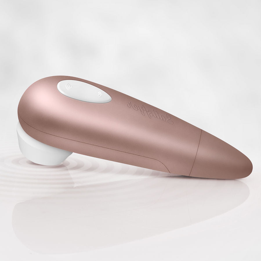 Satisfyer 1 Next Generation Druckwellenstimulator in Roségold liegend auf einer hellen Oberfläche