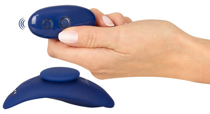 Sweet Smile RC Panty Vibrator Slim in Dunkelblau – Größenvergleich in einer Hand zusammen mit der ovalen Fernbedienung