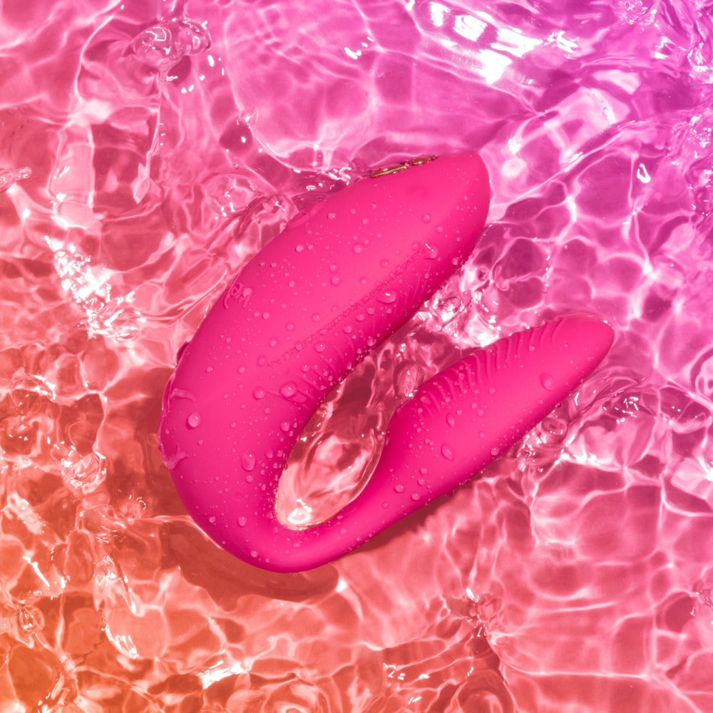 We-Vibe Chorus Pro Paarvibrator in Pink auf farbigem Hintergrund