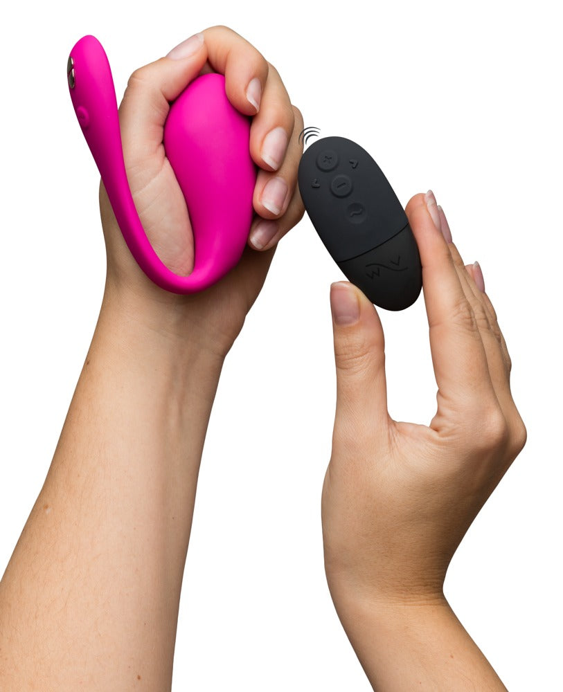We-Vibe Jive 2 Vibro-Ei in Pink mit schwarzer Fernbedienung in der Hand