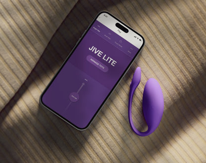 We-Vibe Jive Lite Vibro-Ei in Lila neben einem Smartphone mit geöffneter App