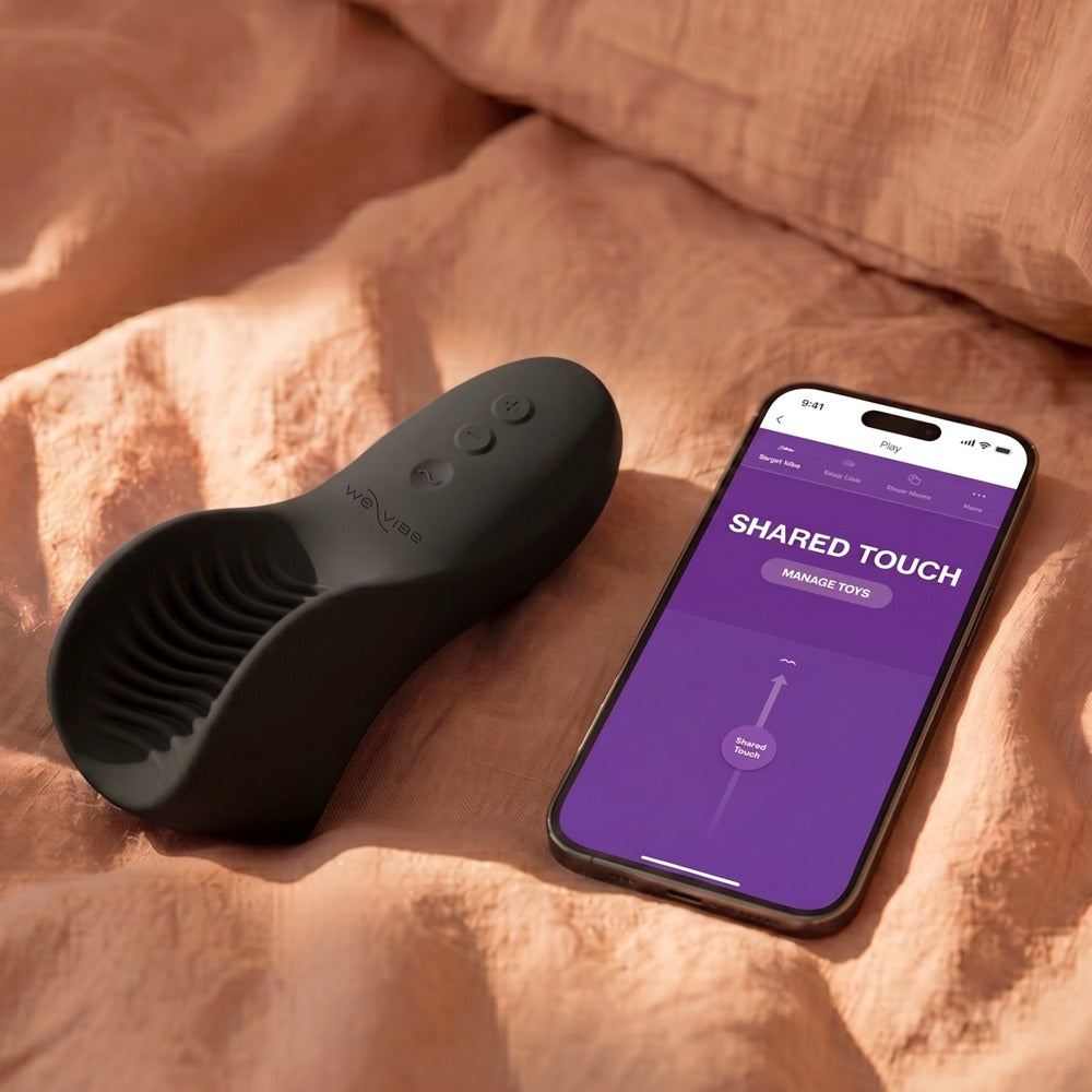 Schwarzer We-Vibe Shared Touch neben Smartphone mit geöffneter We-Vibe App