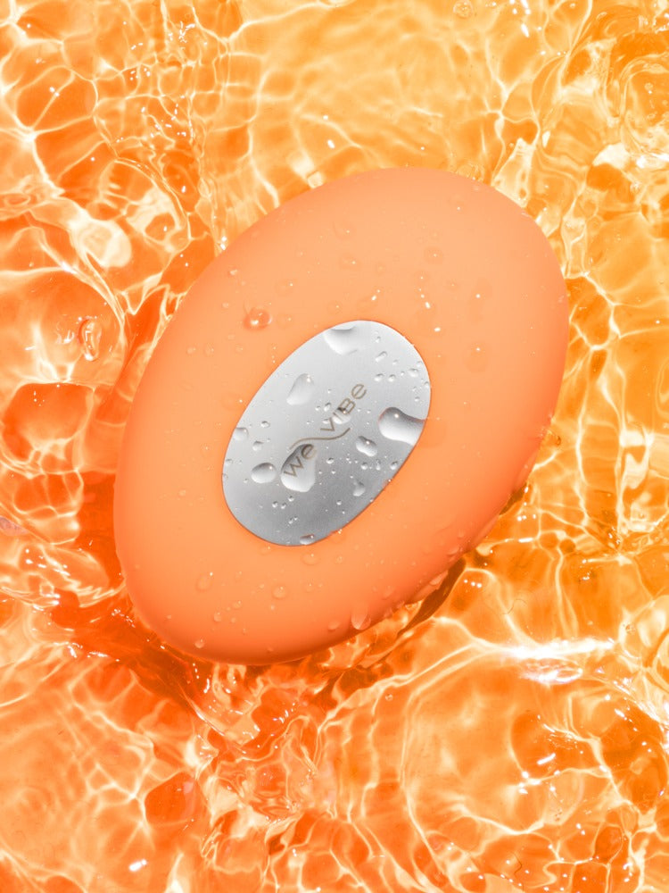 We-Vibe Temp Auflegevibrator in Orange auf leuchtendem Hintergrund
