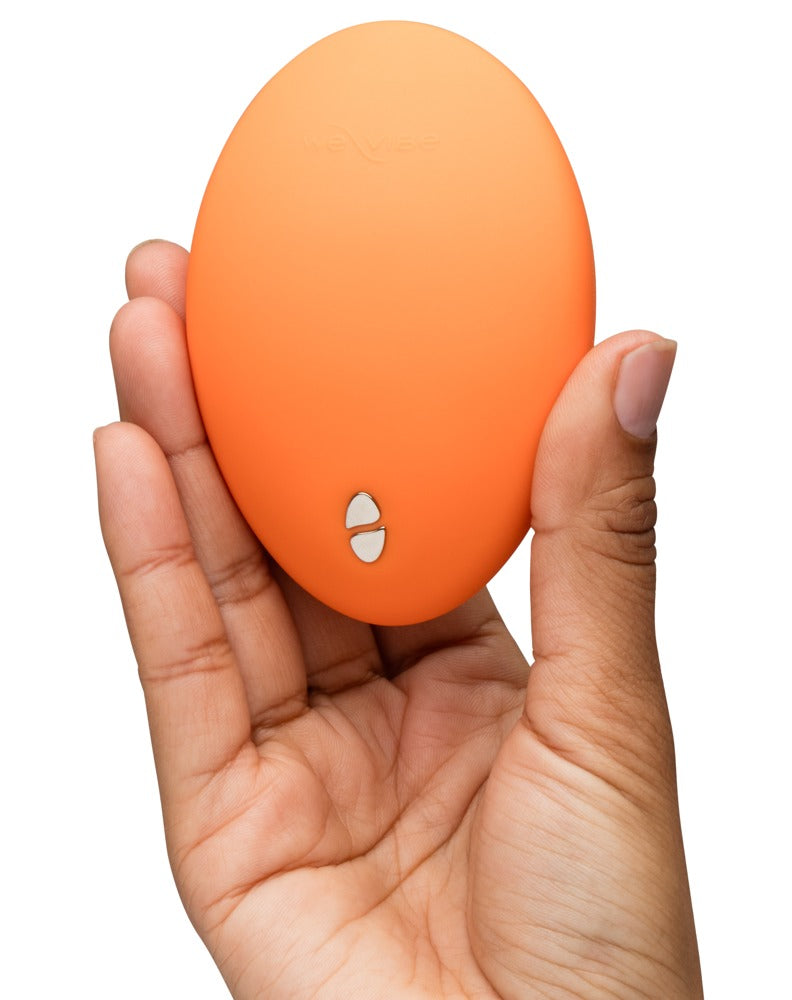 We-Vibe Temp Auflegevibrator in Orange zur Darstellung der kompakten Größe in einer Hand