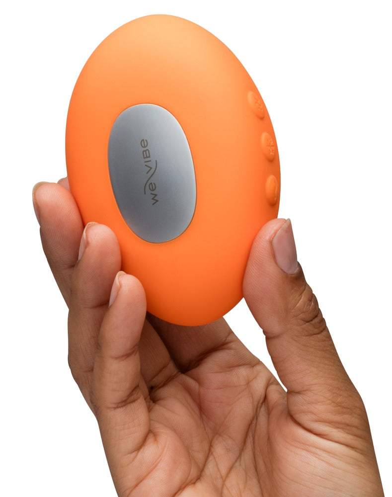 We-Vibe Temp Auflegevibrator in Orange in der Hand mit sichtbarer Wärme- und Kältefläche