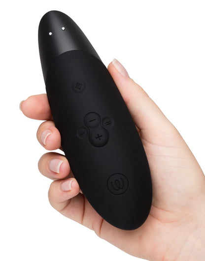 Womanizer Enhance Druckwellenvibrator in der Hand gehalten